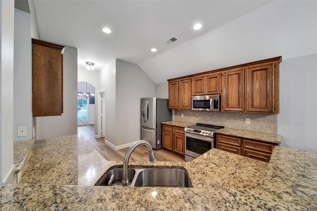 The kitchen will delight your family chef with granite counters, job-built solid wood cabinets, and all stainless steel LG appliances. | Image 11