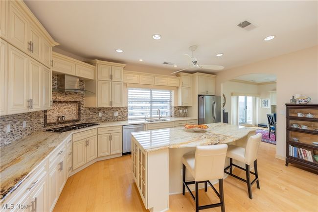 Kitchen with skylight, features granite countertops, large center island, plentiful cabinet space, pantry, stainless steel appliances, high ceilings and private catering entrance. | Image 9