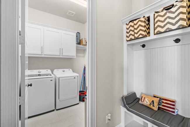 Laundry room featuring washer and dryer, cabinet space, and light tile patterned floors | Image 33