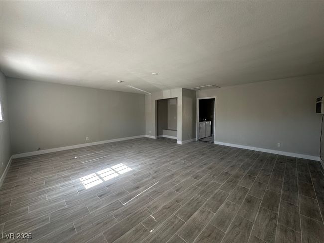 Unfurnished room with dark wood-type flooring, attic access, baseboards, and a textured ceiling | Image 20
