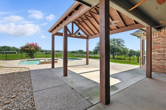 Fenced backyard featuring a ceiling fan, a patio area, and a pool with connected hot tub | Image 28