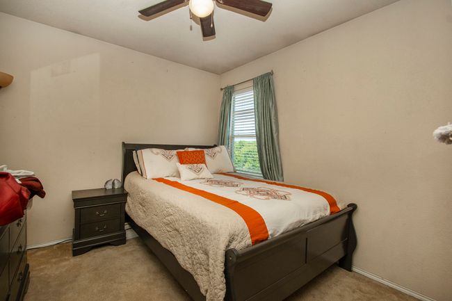 Bedroom featuring carpet flooring, a ceiling fan, and baseboards | Image 12