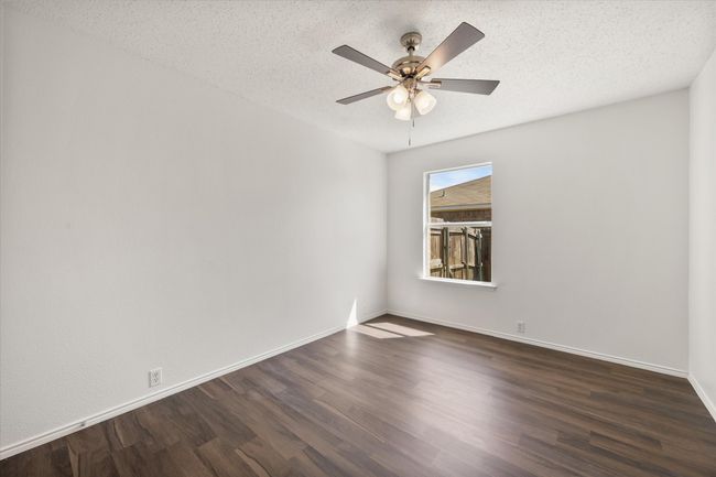 Secondary bedroom with dark wood-style flooring, a ceiling fan, baseboards, and a textured ceiling | Image 22