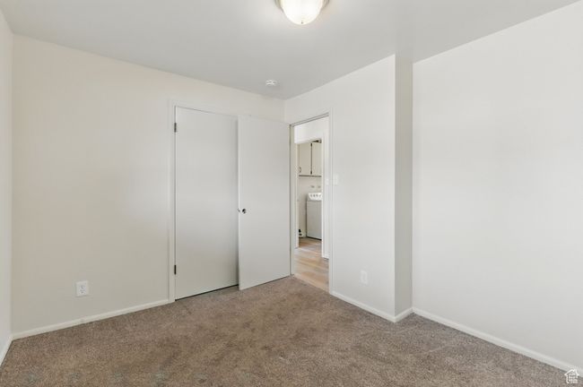 Unfurnished bedroom featuring baseboards, carpet floors, and washer / dryer | Image 15