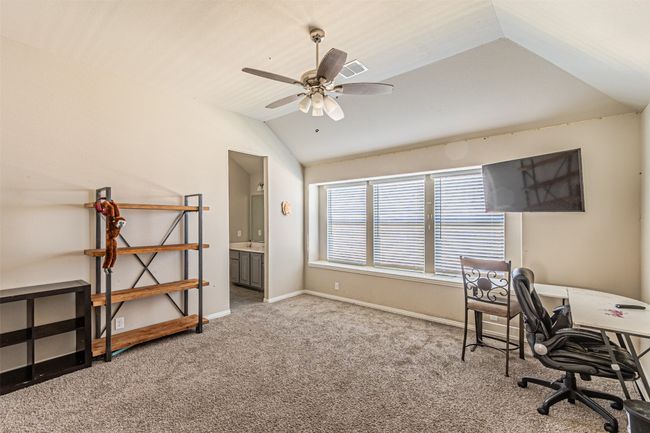 Carpeted office with lofted ceiling, ceiling fan, and baseboards | Image 30