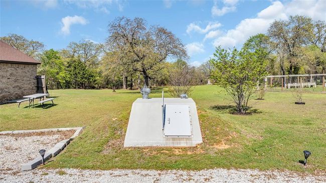 View of storm shelter featuring a lawn | Image 7