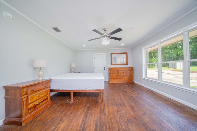 Bedroom featuring dark wood finished floors, crown molding, recessed lighting, and ceiling fan | Image 23