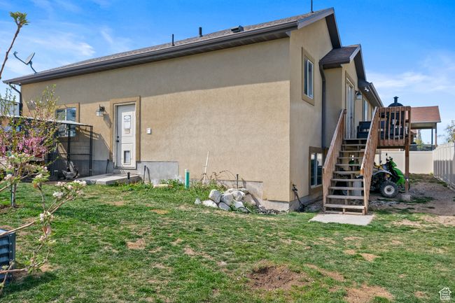 Back of house featuring fence, a wooden deck, stucco siding, stairway, and a yard | Image 40