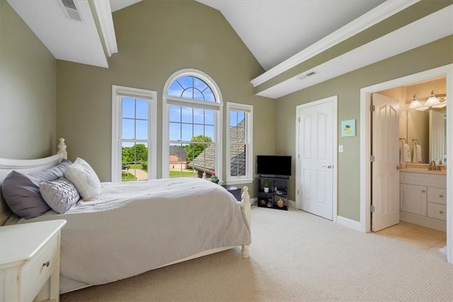 This guest bedroom features a cathedral ceiling, rope lighting, walk-in closet plus its own private full bathroom. | Image 29