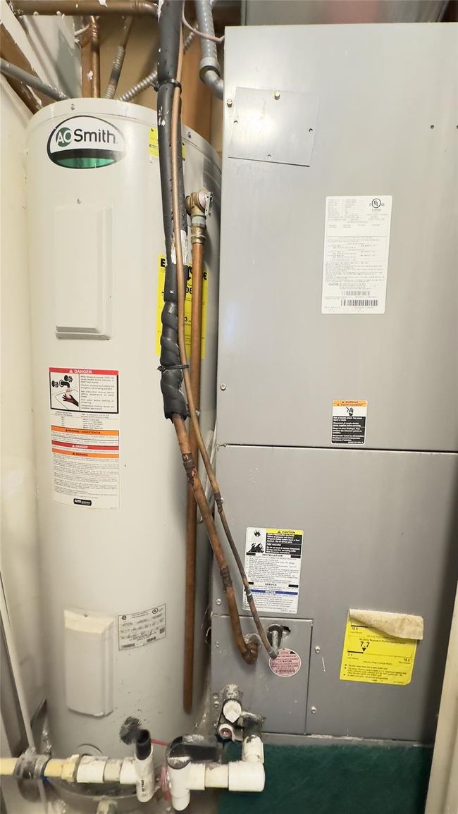 Utility room featuring electric water heater and heating unit | Image 14