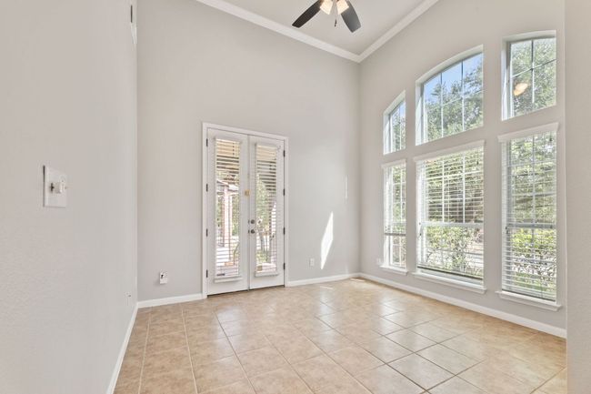Spare room featuring french doors, light tile patterned flooring, ornamental molding, a ceiling fan, and a towering ceiling | Image 7