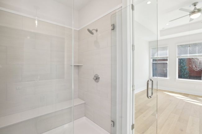 Bathroom with a shower stall, a ceiling fan, wood finished floors, and baseboards | Image 23