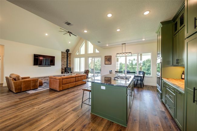 Kitchen featuring a center island, dark hardwood / wood-style floors, a breakfast bar area, and green cabinets | Image 8