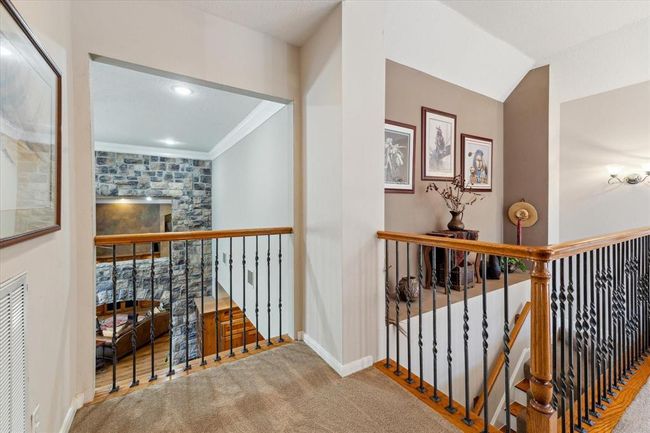 The sprawling second floor is spacious and flows effortlessly between the game room, additional family room on the second level and the upstairs bedroom en-suite. The balcony overlooks the main first floor living room below and allows light to stream in from both sides of the home. The sturdy railing lining the balcony and staircase is supported by carefully selected and imported French forged natural blued iron spindles. | Image 28