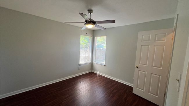 Unfurnished room featuring ceiling fan, dark wood-type flooring, and baseboards | Image 7