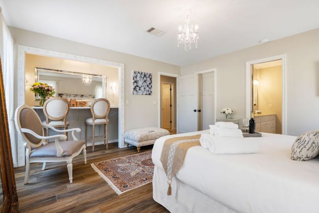 Bedroom featuring a chandelier, wood finished floors, baseboards, and ensuite bathroom | Image 21