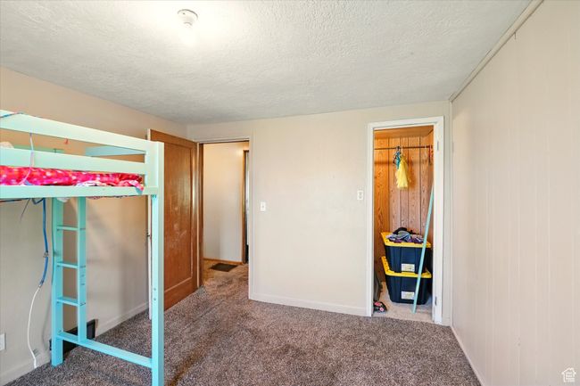 Unfurnished bedroom featuring carpet floors, a textured ceiling, and baseboards | Image 11