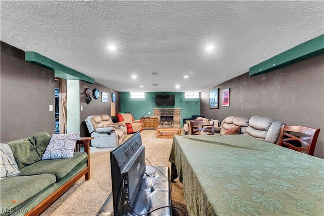 Living room with light colored carpet, a fireplace, recessed lighting, and a textured ceiling | Image 31