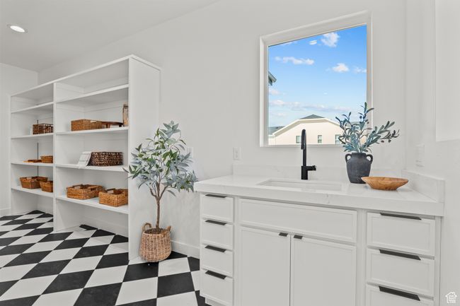 Interior space with dark floors, white cabinetry, and light stone counters | Image 24