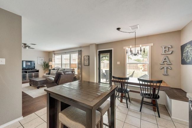 Dining area with a chandelier, light tile patterned flooring, and a ceiling fan | Image 12