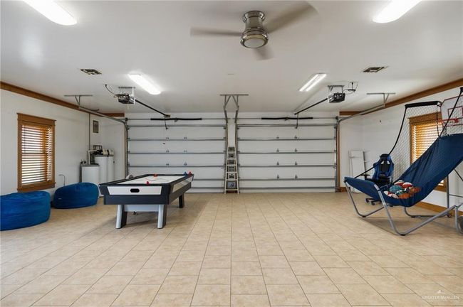 Garage with ceiling fan and a garage door opener | Image 10