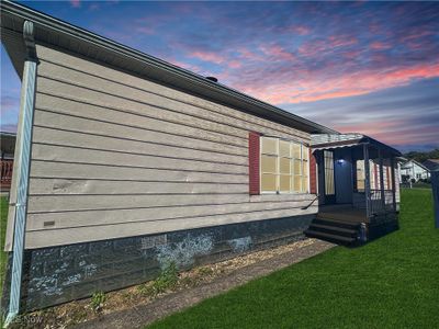 Property exterior at dusk featuring a yard | Image 1