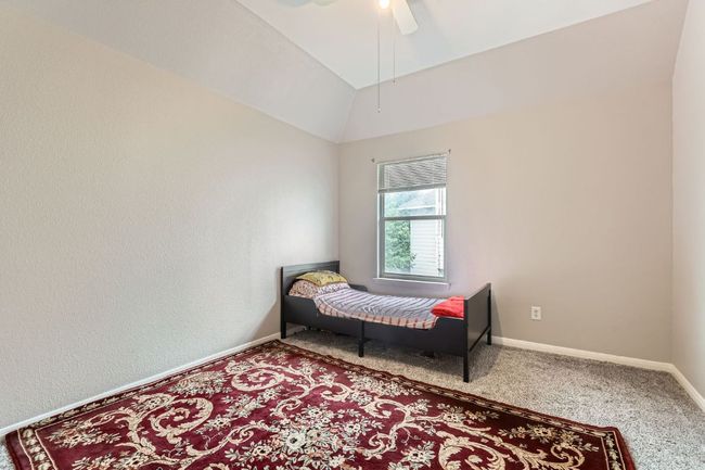Carpeted bedroom with lofted ceiling and a ceiling fan | Image 23