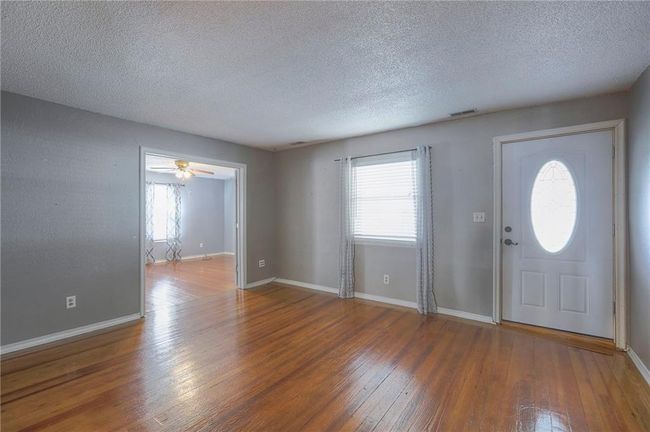 Entrance foyer featuring plenty of natural light, baseboards, a textured ceiling, and wood-type flooring | Image 39