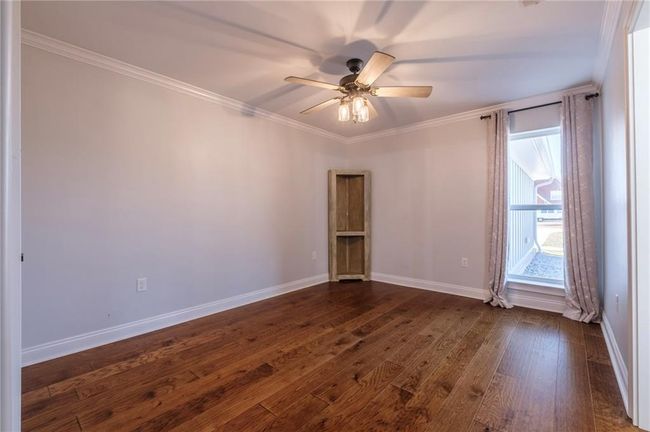 Unfurnished room with crown molding, ceiling fan, and dark wood-type flooring | Image 21