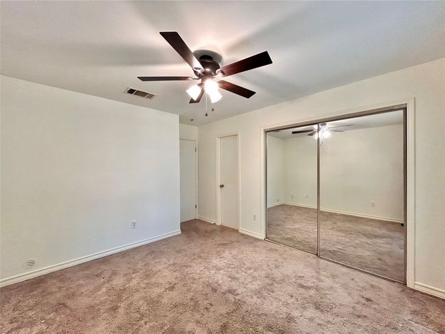 Unfurnished bedroom with carpet floors, ceiling fan, and a closet | Image 11