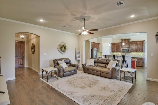 Large Living area featuring arched walk way and wood finish floors | Image 5