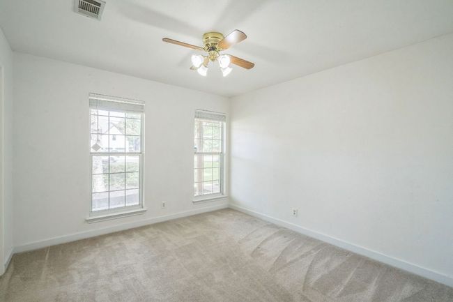 Carpeted room with ceiling fan and large closet with shelves | Image 20