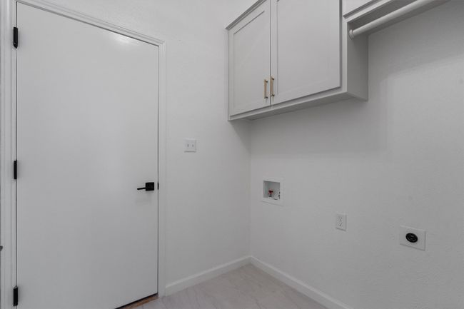 Washroom featuring cabinet space, baseboards, hookup for a washing machine, and electric dryer hookup | Image 24