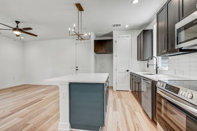 Kitchen with appliances with stainless steel finishes, a sink, light wood-style floors, recessed lighting, and a kitchen island | Image 4