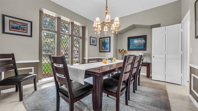 Dining room featuring light tile patterned floors and a chandelier | Image 23