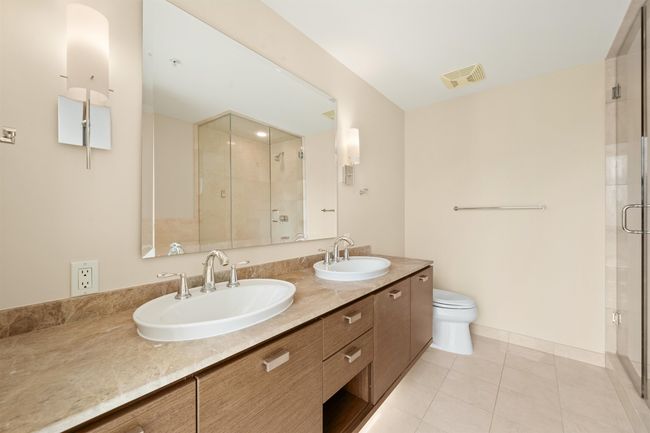 Bathroom featuring visible vents, a sink, and a shower stall | Image 7