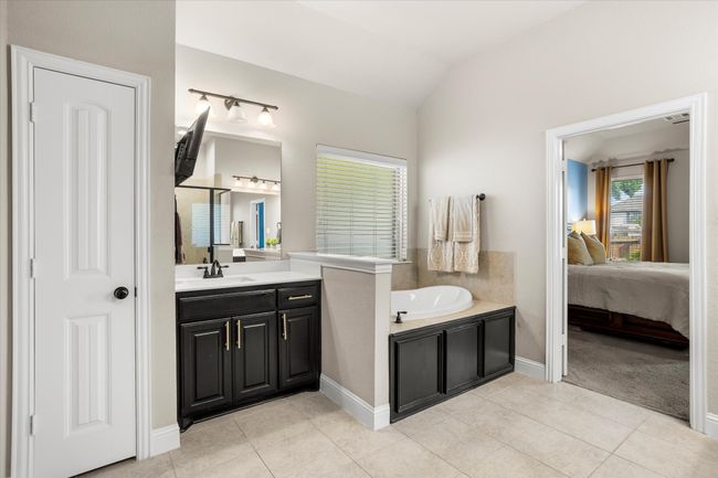 Ensuite bathroom with lofted ceiling, tile patterned flooring, vanity, and ensuite bathroom | Image 21