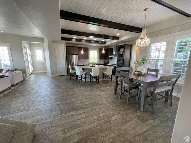 Dining area featuring beam ceiling, a chandelier, and wood-style tile floors | Image 10