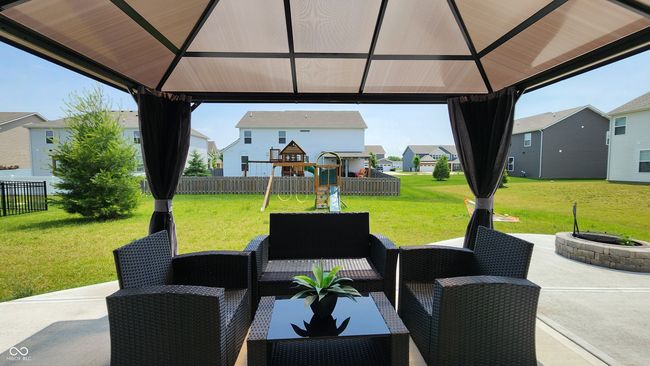 view of patio / terrace with a gazebo, a playground, a residential view, and an outdoor living space with a fire pit | Image 22