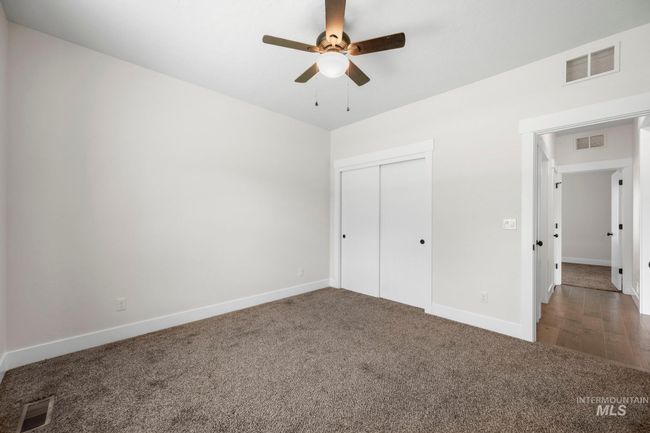 Unfurnished bedroom with carpet, a closet, and a ceiling fan | Image 27