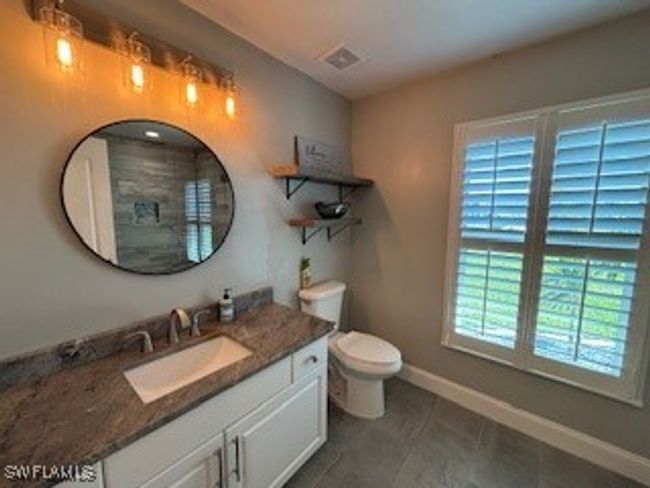 Bathroom featuring toilet, vanity, baseboards, and visible vents | Image 16