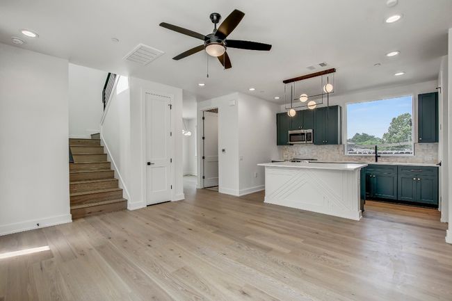 Kitchen featuring stainless steel microwave, backsplash, a sink, light countertops, and recessed lighting | Image 6