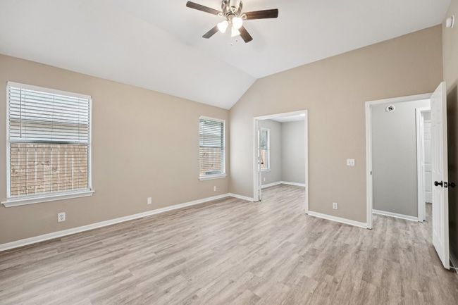 Unfurnished bedroom with vaulted ceiling, light wood finished floors, and a ceiling fan | Image 18