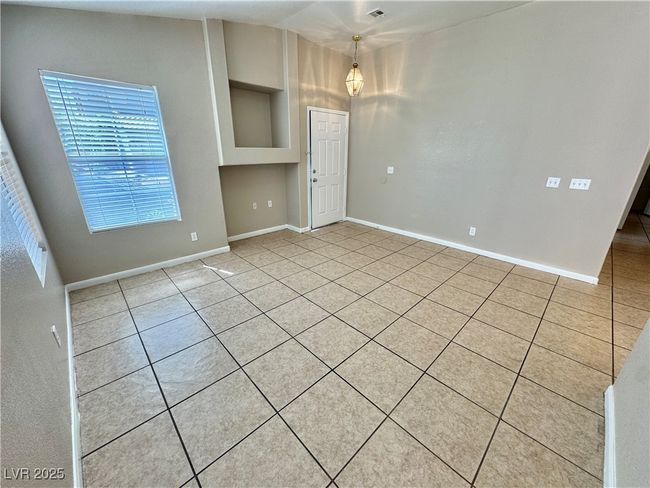 Empty room with baseboards, built in shelves, and light tile patterned floors | Image 4