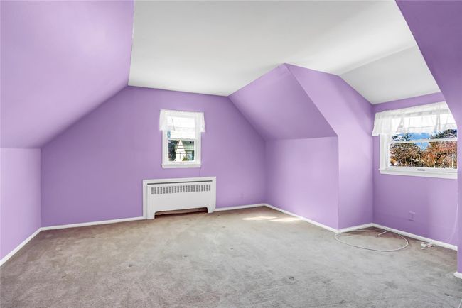 Additional living space featuring carpet flooring, radiator, a healthy amount of sunlight, and baseboards | Image 18