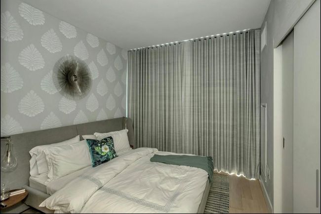 Bedroom with wallpapered walls and wood finished floors | Image 14