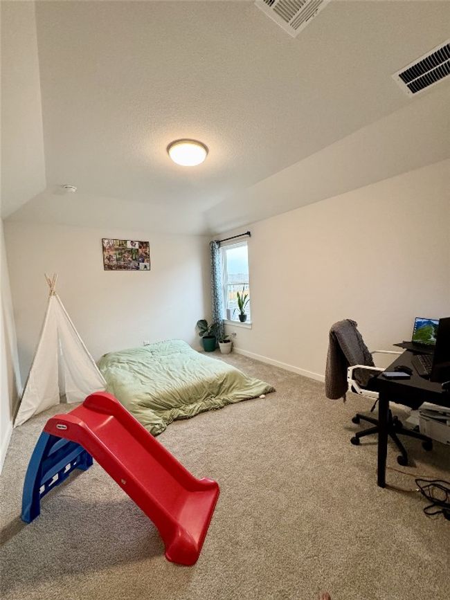 Bedroom featuring carpet floors, baseboards, and an office area | Image 12