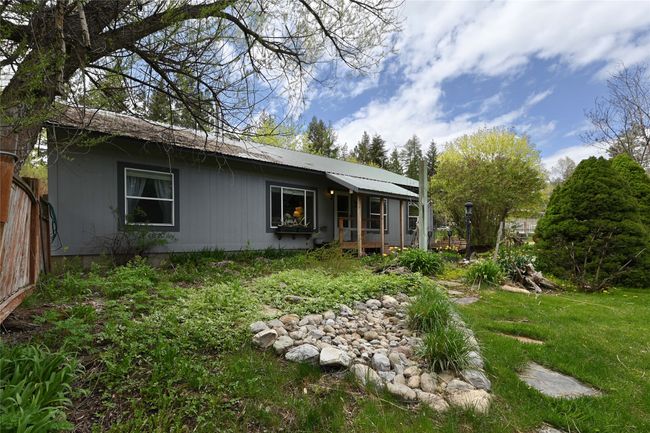 Rear view of property featuring metal roof and a yard | Image 52