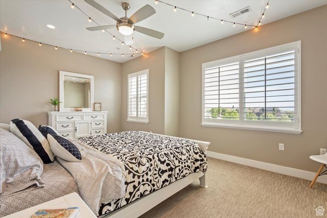 Carpeted bedroom with baseboards, multiple windows, and ceiling fan | Image 23