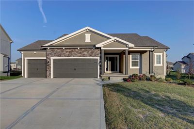 View of front facade featuring a front yard and a garage | Image 1